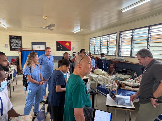 Pediatric surgeons performing a procedure under surgical lights.